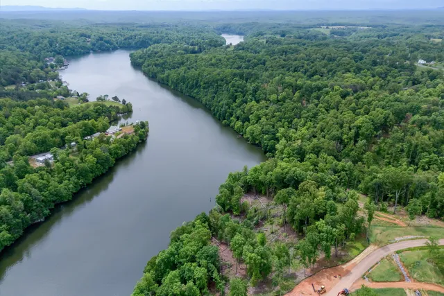 an aerial view of residential house with outdoor space and trees all around