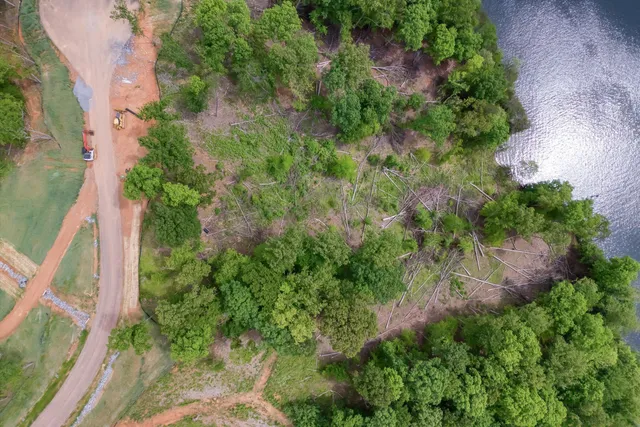 an aerial view of a house with a yard and lake view