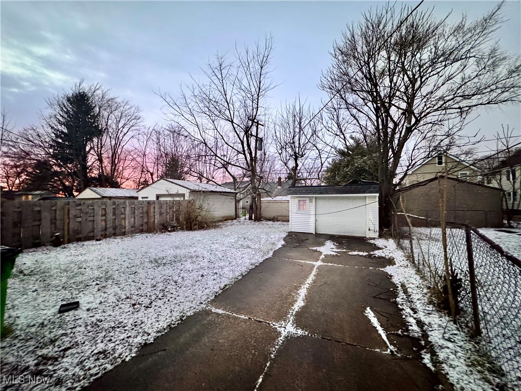 4770 Burleigh Road Cleveland, OH 44125 - Photo 21 of 22 Yard layered in snow featuring a detached garage, an outbuilding, and driveway