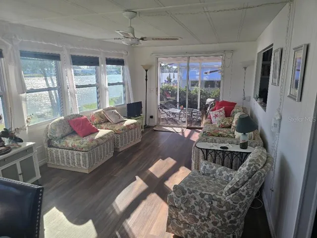 a living room with furniture a flat screen tv and a floor to ceiling window