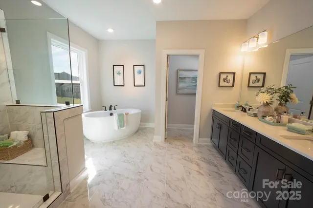 a spacious bathroom with a double vanity sink a mirror and a bathtub