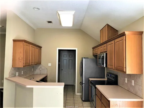 a kitchen with stainless steel appliances granite countertop a sink a refrigerator and a stove