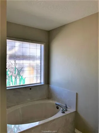 a bathroom with a bathtub and window