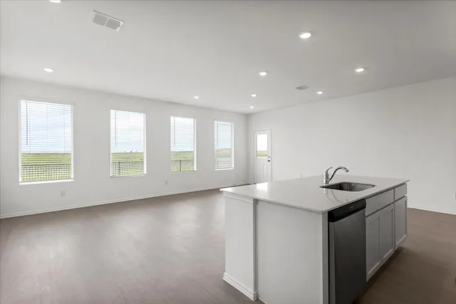 a kitchen with kitchen island sink stove and cabinets