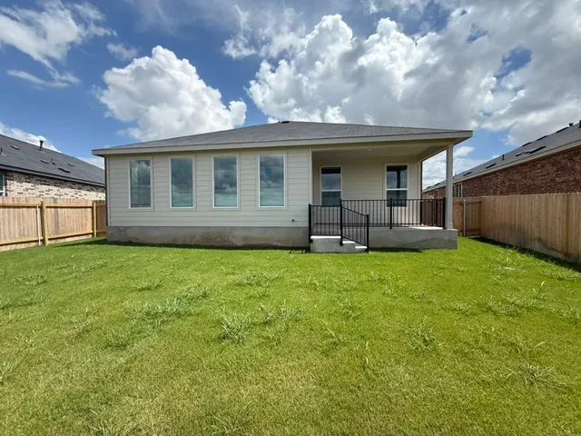 a view of a house with backyard and sitting area