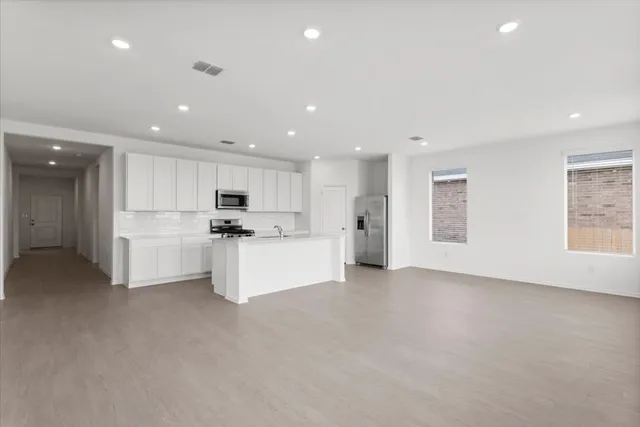 a view of kitchen with kitchen island white cabinets and white appliances