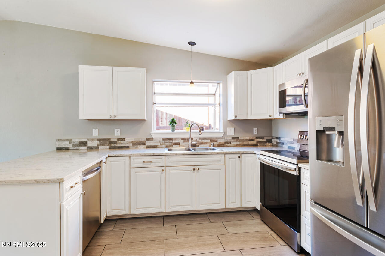 3560 Haystack Drive Carson City, NV 89705 - Photo 15 of 23 a kitchen with stainless steel appliances granite countertop a stove a sink and a refrigerator
