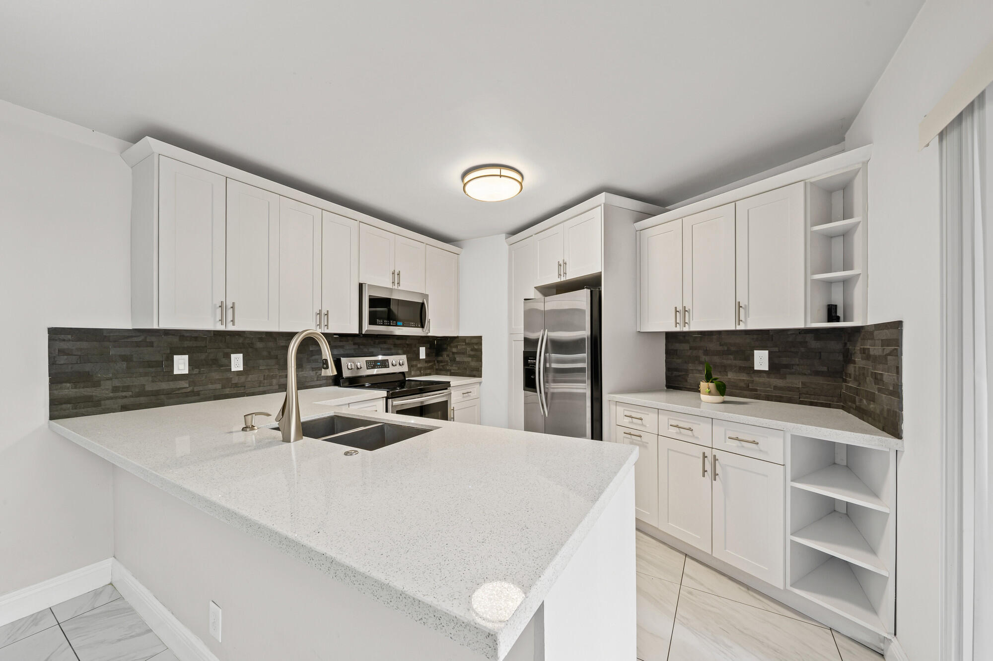 8194 Thames Boulevard, Unit B Boca Raton, FL 33433 - Photo 6 of 49 a kitchen with stainless steel appliances a refrigerator a stove a sink and white cabinets