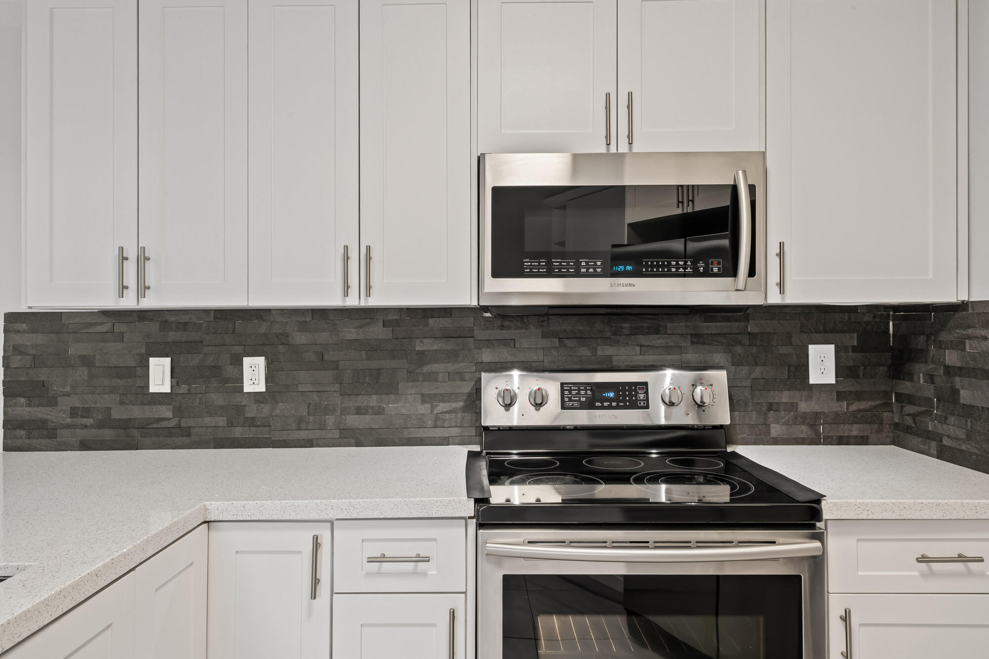 8194 Thames Boulevard, Unit B Boca Raton, FL 33433 - Photo 7 of 49 a kitchen with granite countertop white cabinets and stainless steel appliances