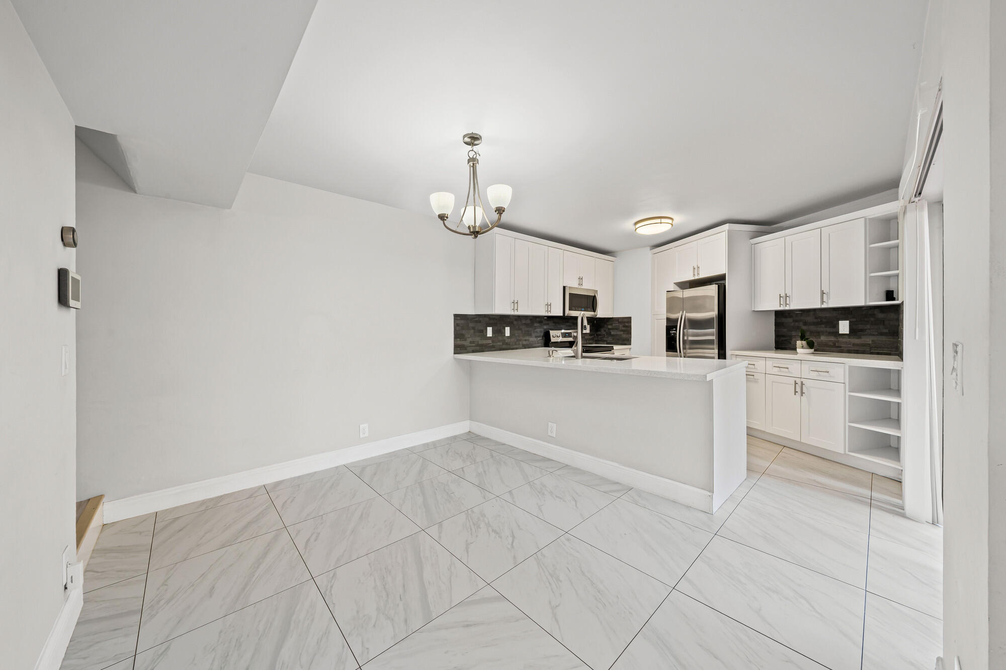 8194 Thames Boulevard, Unit B Boca Raton, FL 33433 - Photo 9 of 49 a kitchen with cabinets and window