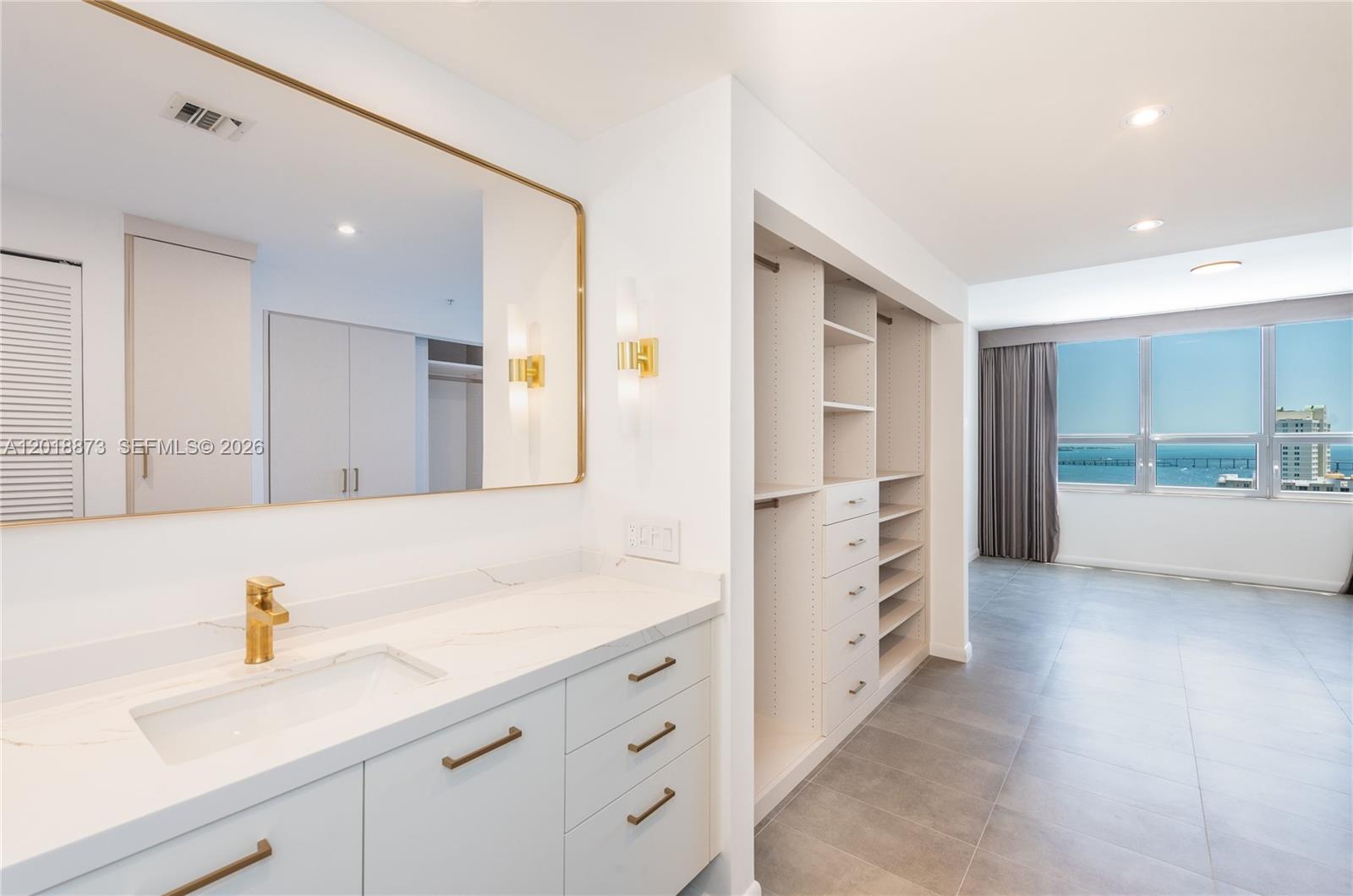 848 Brickell Key Drive, Unit 2703 Miami, FL 33131 - Photo 14 of 30 a spacious bathroom with a shower sink and a mirror