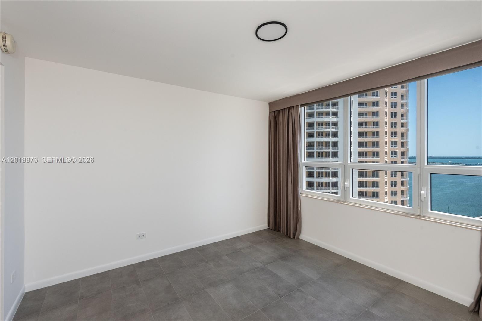 848 Brickell Key Drive, Unit 2703 Miami, FL 33131 - Photo 17 of 30 an empty room with a window