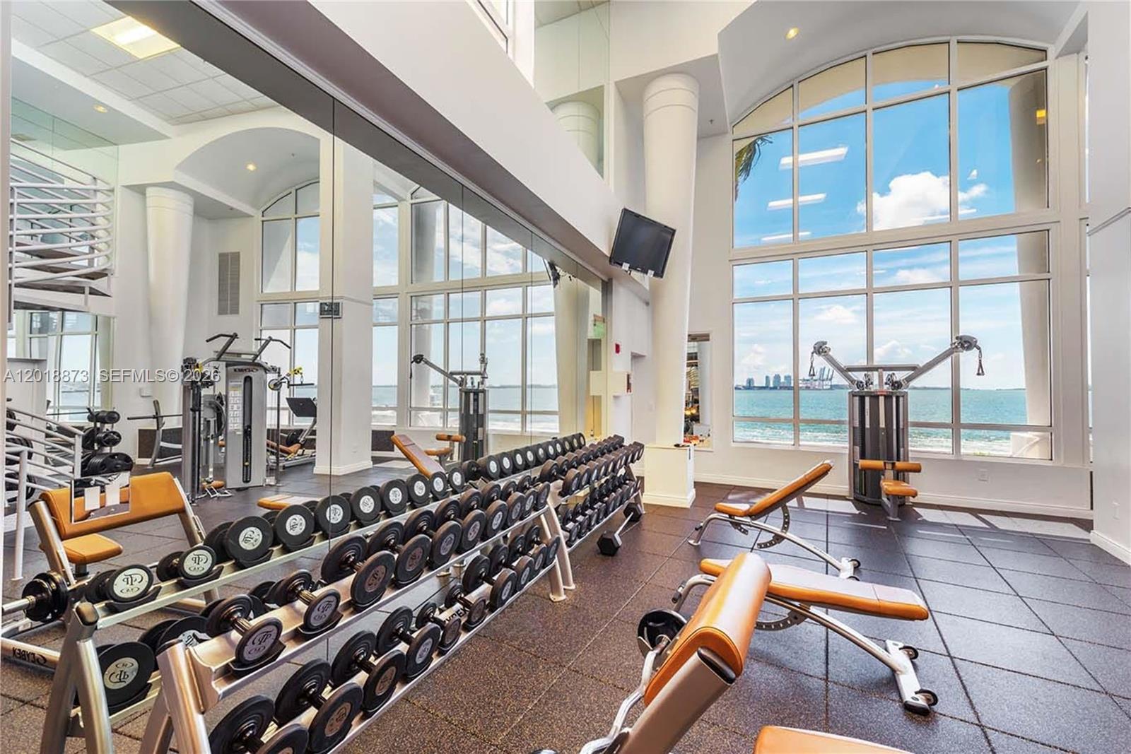 848 Brickell Key Drive, Unit 2703 Miami, FL 33131 - Photo 23 of 30 a room with lots of chairs and mirrors