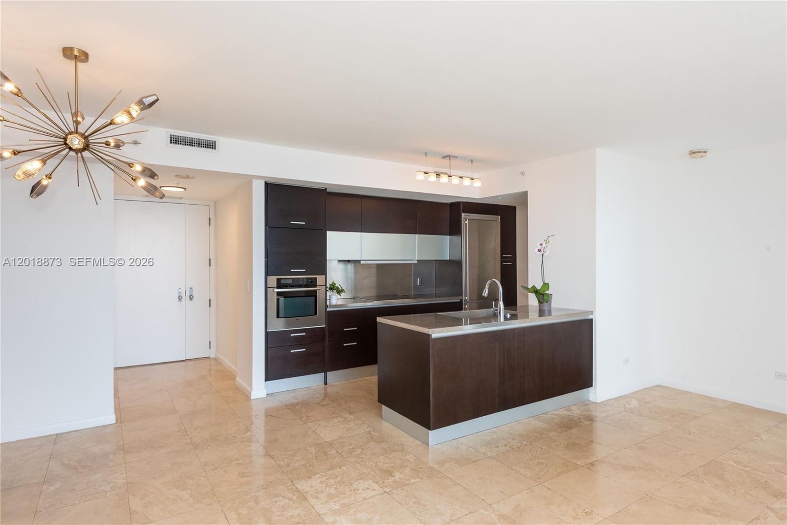 848 Brickell Key Drive, Unit 2703 Miami, FL 33131 - Photo 8 of 30 a kitchen with stainless steel appliances a stove top oven a sink and dishwasher