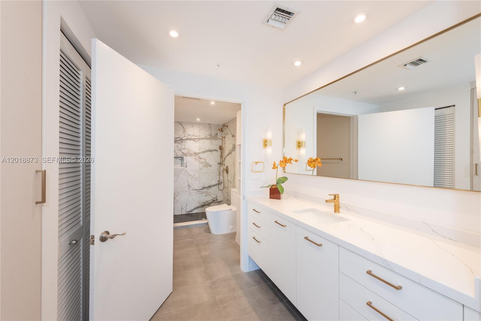 848 Brickell Key Drive, Unit 2703 Miami, FL 33131 - Photo 9 of 30 a spacious bathroom with a shower a sink and a large mirror