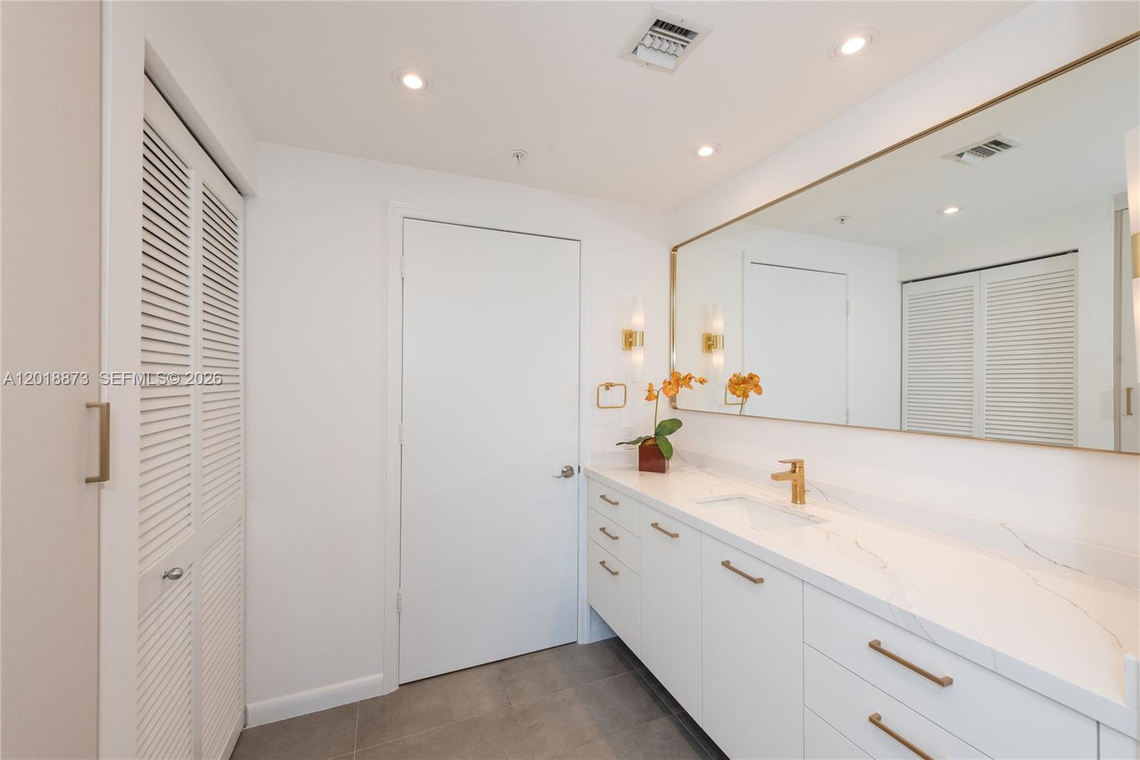 848 Brickell Key Drive, Unit 2703 Miami, FL 33131 - Photo 10 of 30 a bathroom with a sink a mirror and a shower