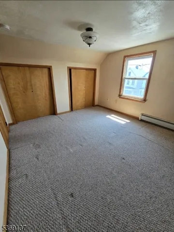 an empty room with windows and cabinet