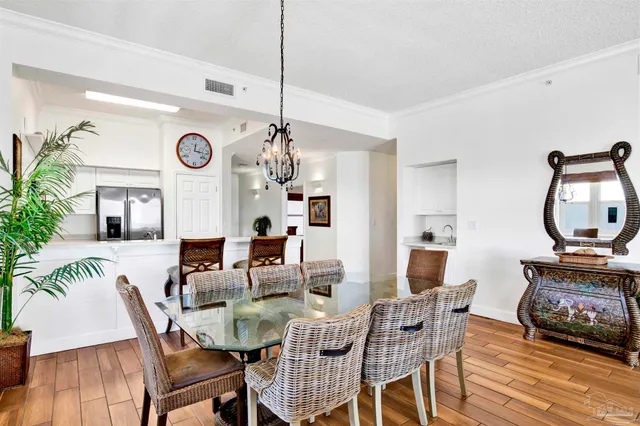 a view of a dining room with furniture a chandelier and wooden floor