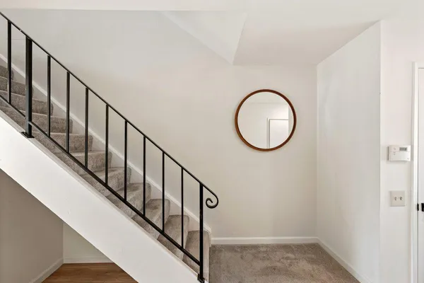 a view of a hallway with wooden floor and staircase