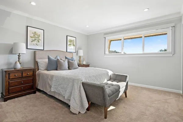 a bedroom with a bed and a painting on the wall