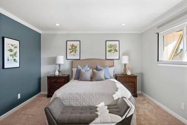 a bed room with a bed and painting on the wall