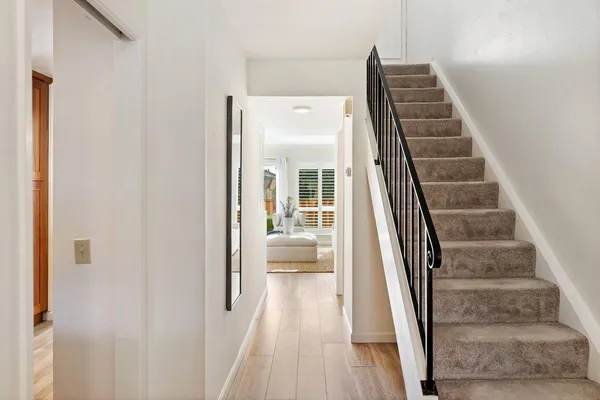 a view of a hallway with wooden floor and entryway