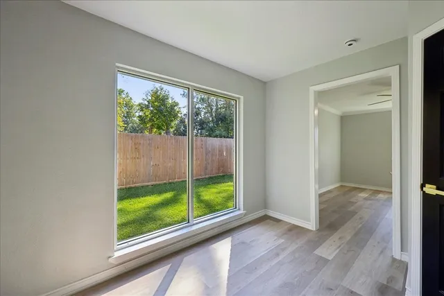 a view of a room with window wooden floor and front door