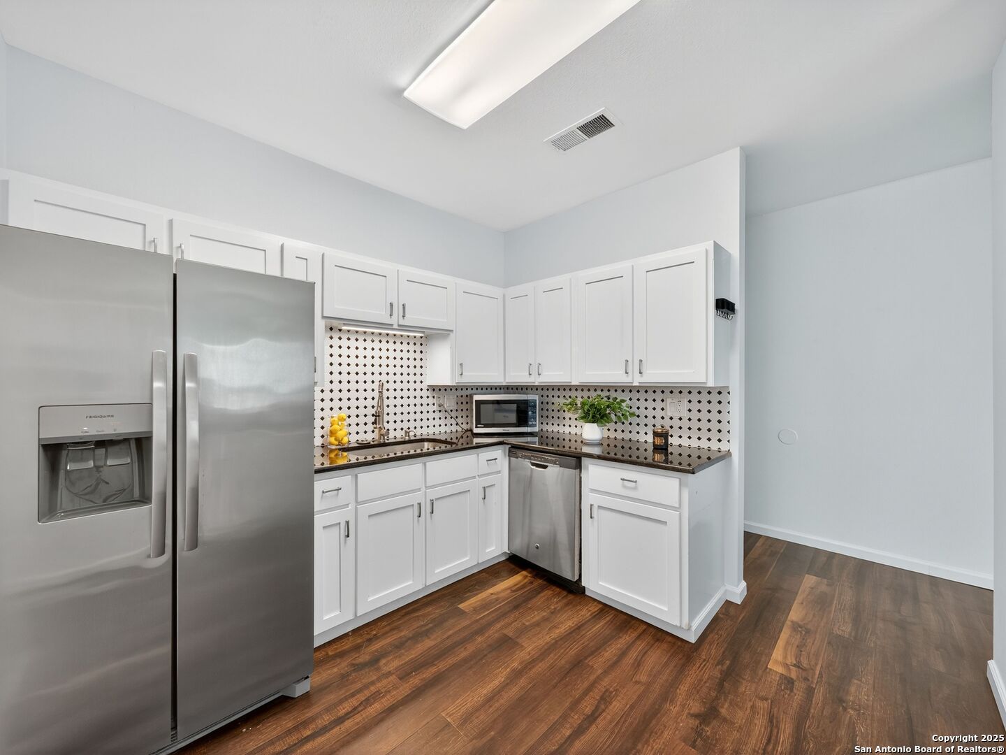 2414 Longview Street, Unit 307 Austin, TX 78705 - Photo 13 of 26 a kitchen with stainless steel appliances granite countertop a refrigerator a sink dishwasher a stove and white countertops with wooden floor