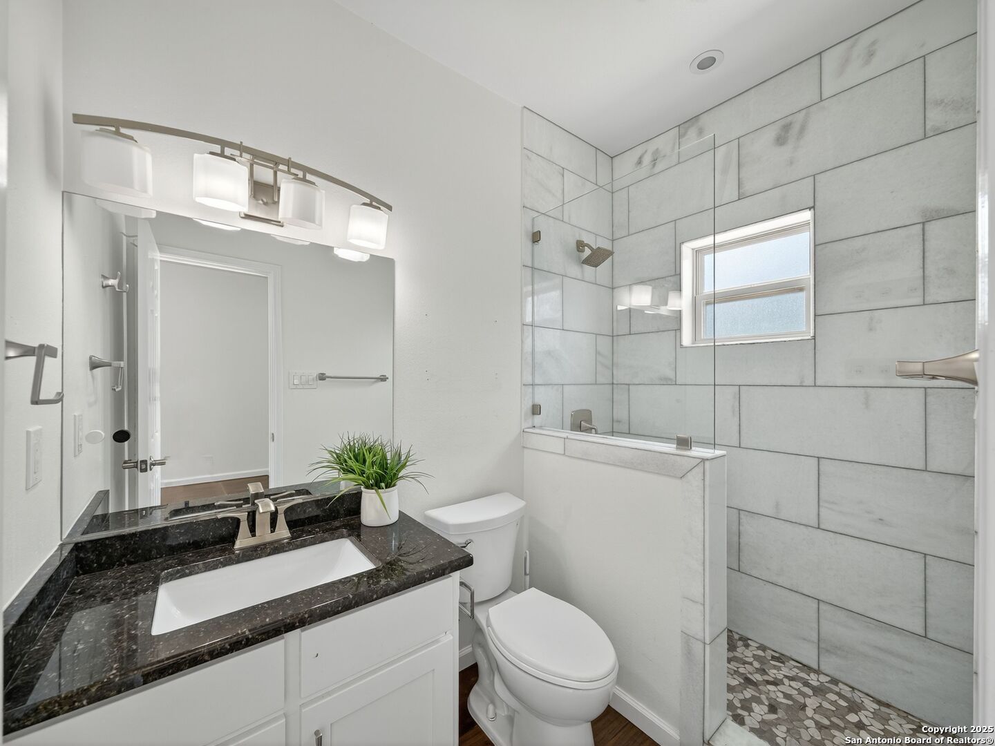 2414 Longview Street, Unit 307 Austin, TX 78705 - Photo 19 of 26 a bathroom with a granite countertop sink a mirror and a toilet