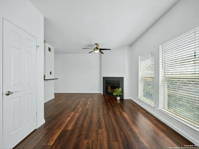 a view of empty room with wooden floor and fireplace