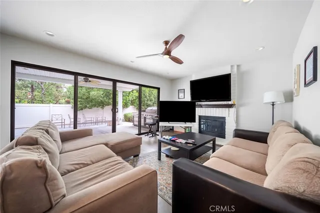 a living room with furniture a flat screen tv and a large window