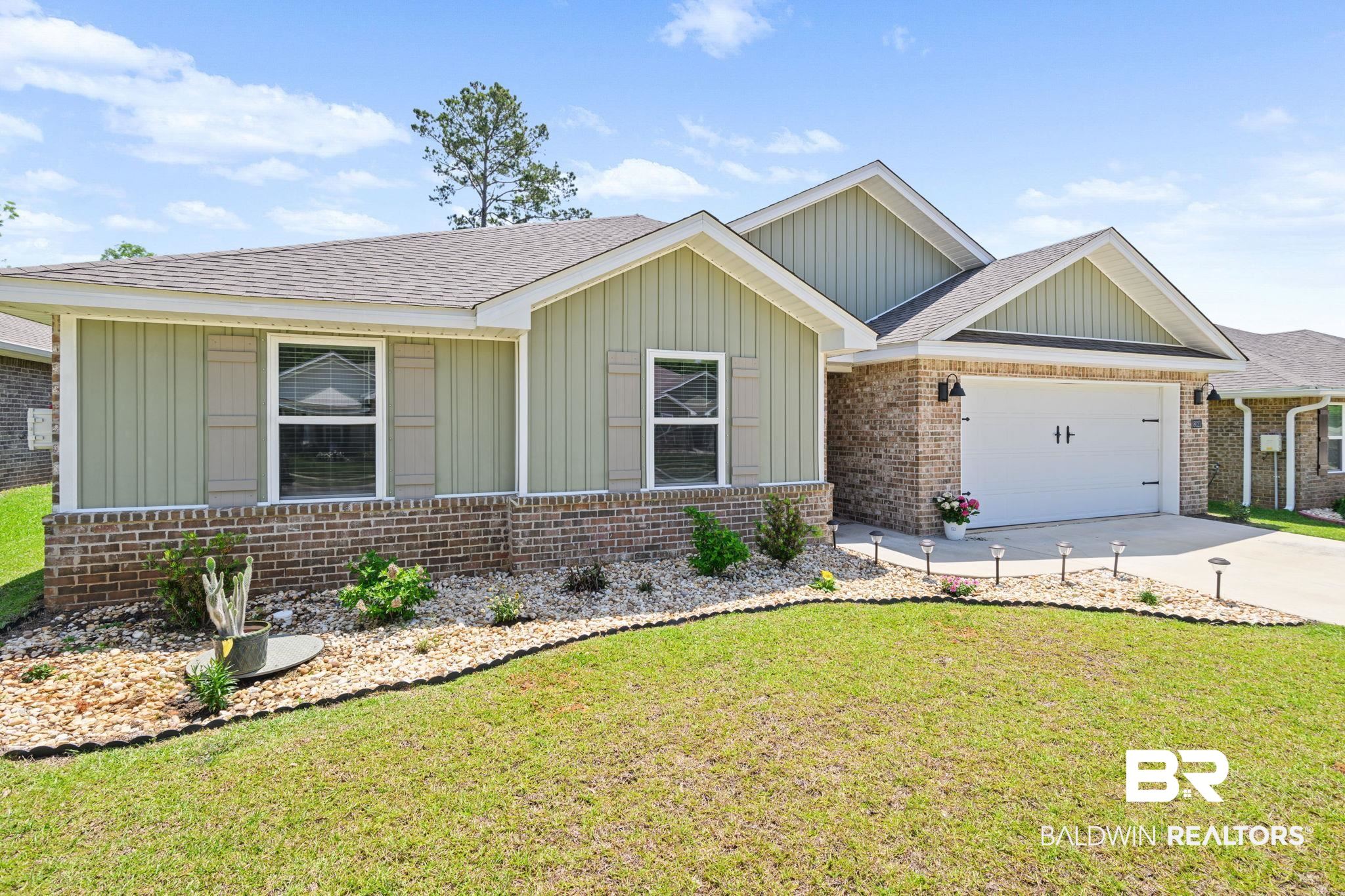 8021 Valor Rdg Way North Mobile, AL 36619 - Photo 4 of 34 Front exterior featuring a combination of brick and vertical siding, a paved driveway, and a two-car garage