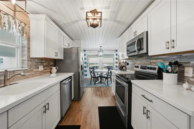 a kitchen with kitchen island granite countertop lots of counter top space a sink appliances and cabinets