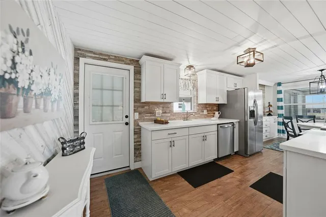 a large kitchen with stainless steel appliances granite countertop a stove and a sink