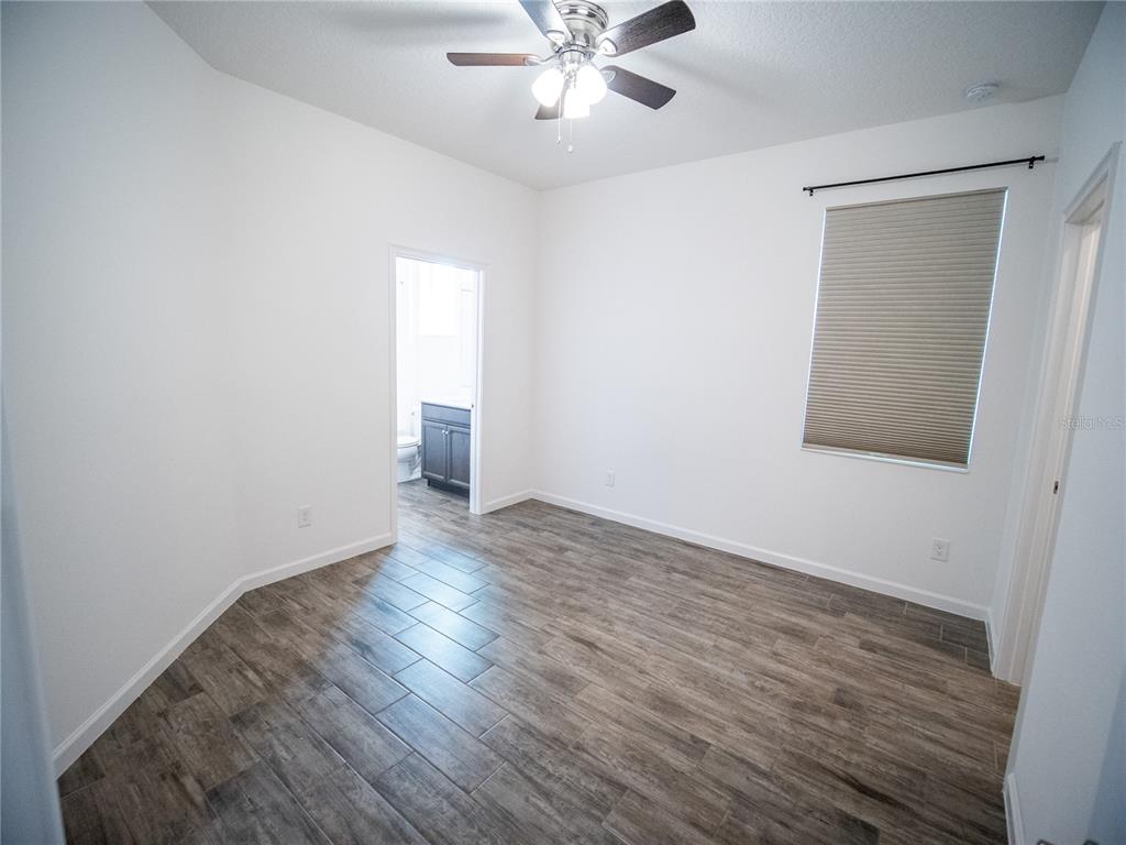 1257 Hendon Loop Davenport, FL 33837 - Photo 14 of 16 an empty room with wooden floor and windows