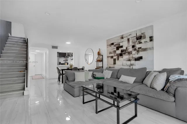 a living room with furniture a rug and white walls