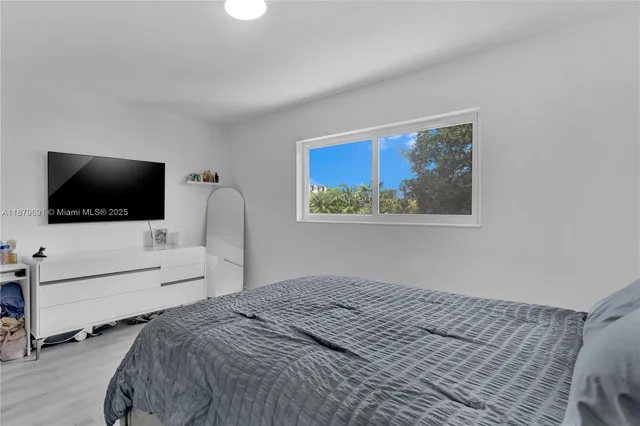 a bedroom with a bed and a flat screen tv