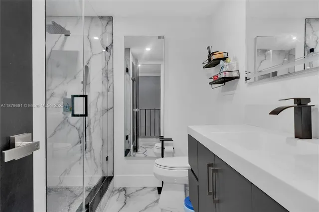 a bathroom with a sink a toilet and shower