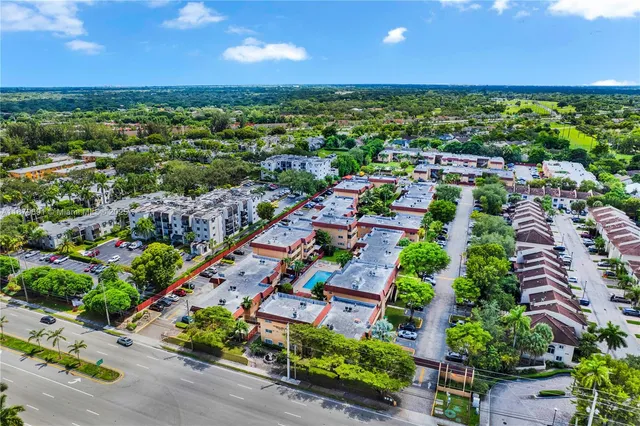an aerial view of residential houses with outdoor space and trees