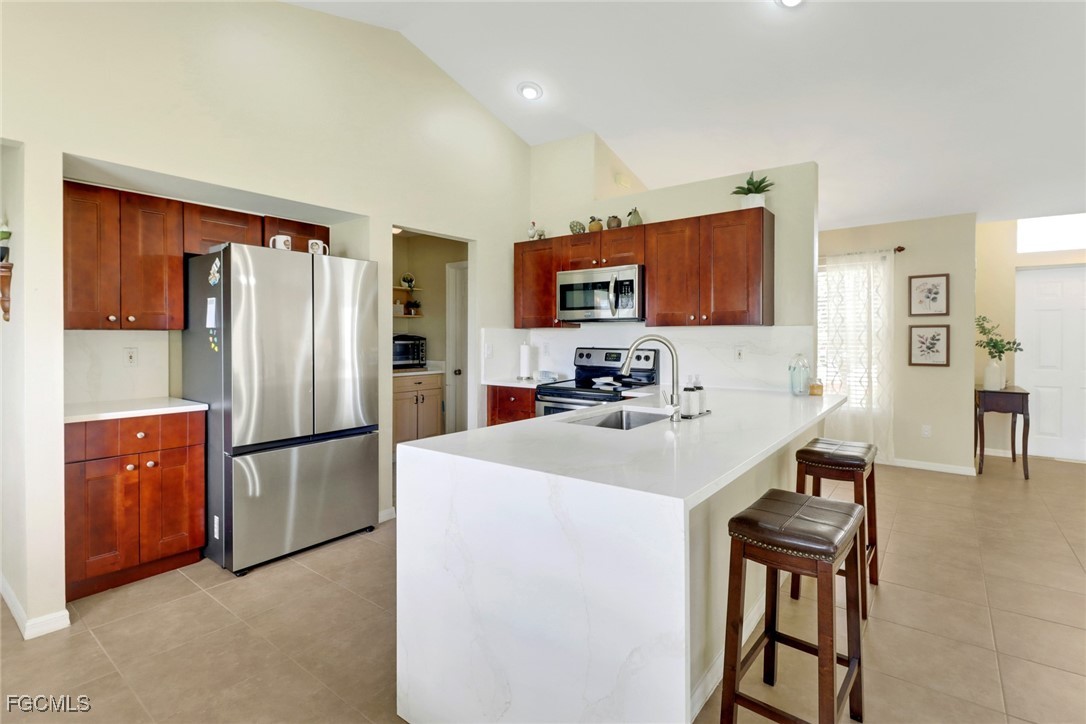 a kitchen with stainless steel appliances a refrigerator stove microwave and sink