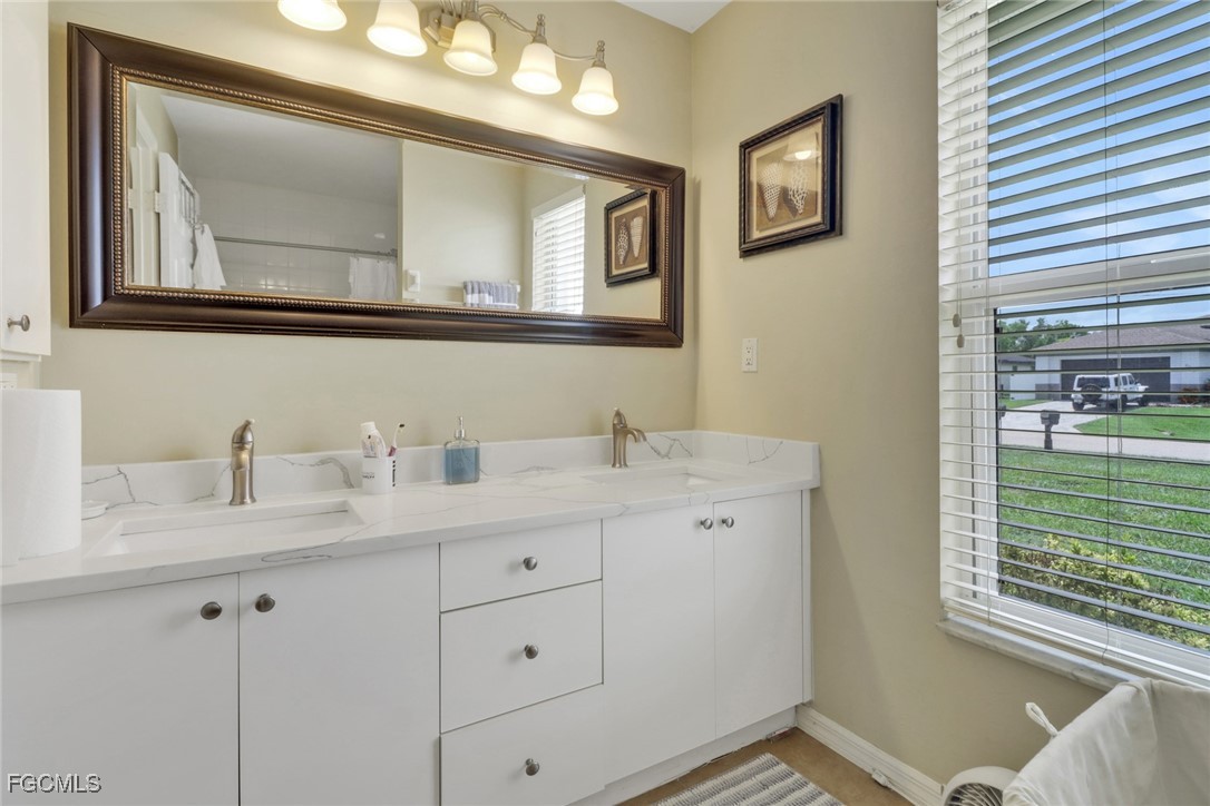 2223 Southwest 16th Terrace Cape Coral, FL 33991 - Photo 9 of 11 a bathroom with a granite countertop sink vanity and mirror