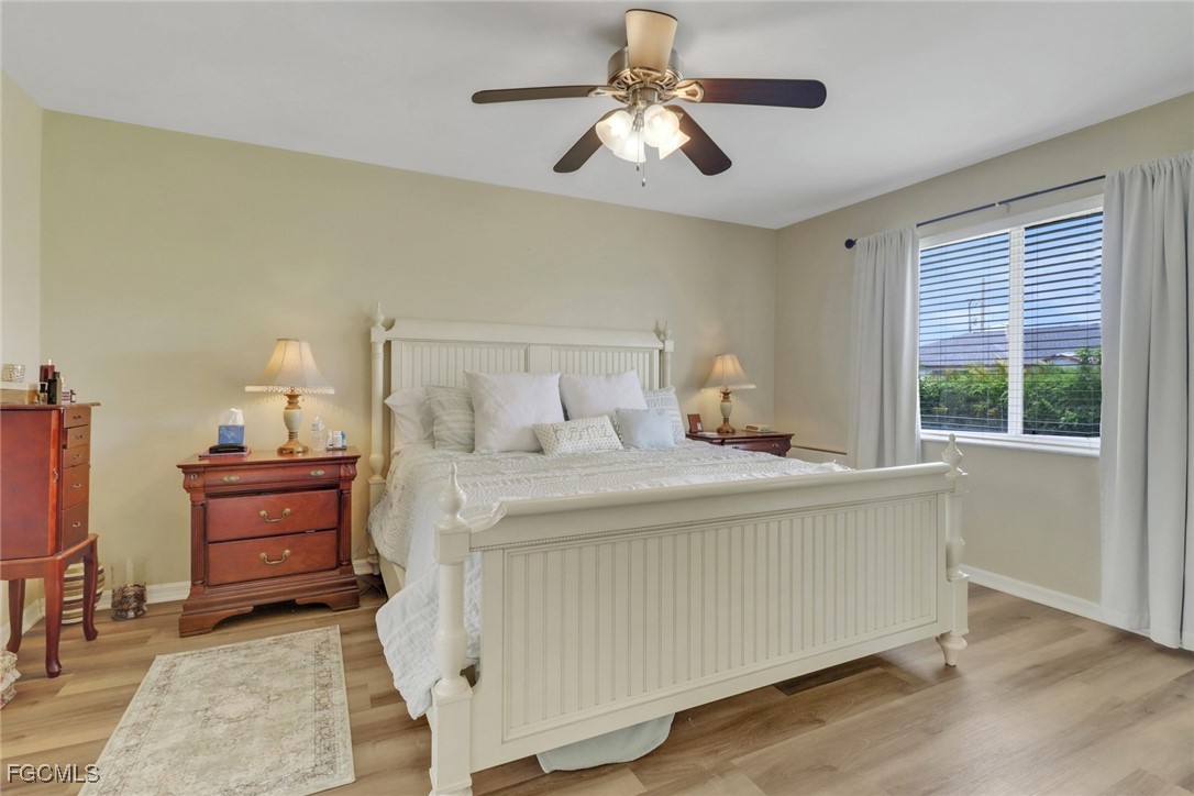 2223 Southwest 16th Terrace Cape Coral, FL 33991 - Photo 10 of 11 a bedroom with a bed and a chandelier
