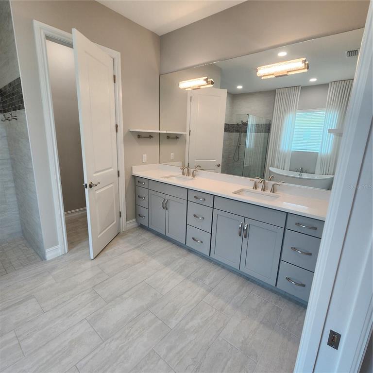512 Blue Shell Loop Sarasota, FL 34240 - Photo 21 of 44 a bathroom with a double vanity sink and mirror