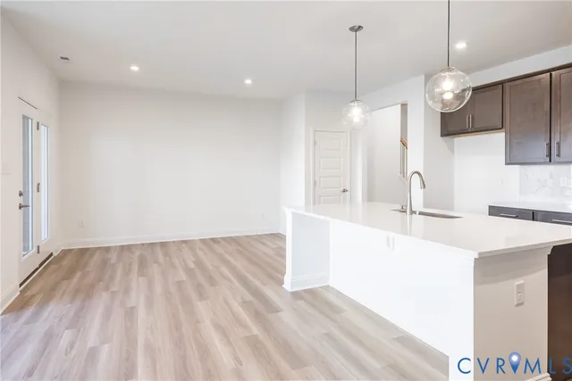a view of a kitchen with a sink wooden floor and a chandelier