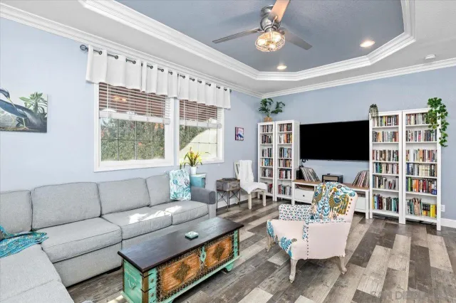 a living room with furniture a flat screen tv and a large window