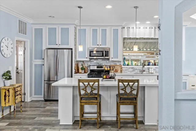 a kitchen with stainless steel appliances kitchen island granite countertop a refrigerator and a stove top oven