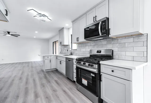 a kitchen with a stove a sink and a microwave