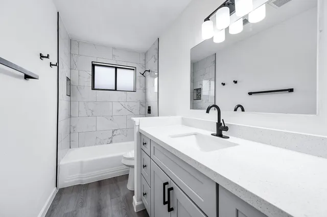 a bathroom with a tub sink and mirror