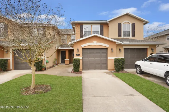 a front view of a house with a yard and garage