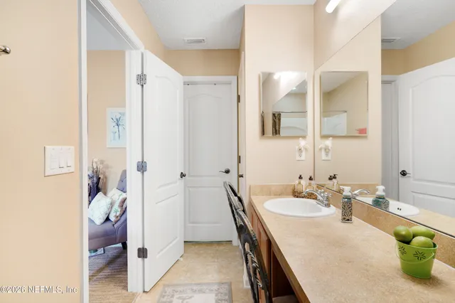 a en suite bathroom with a granite countertop sink and a mirror
